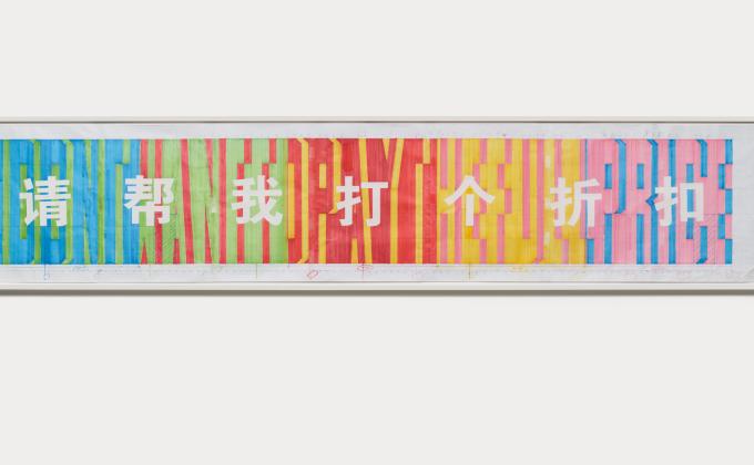  A long piece of white paper marked with scale measurements is filled with colourful text stretching from top to bottom in both English and Mandarin. The English text is in Superstar shadow font and coloured in green, red, yellow, pink and blue. The Mandarin characters are in white and are written over top, like cut outs in the coloured words. 