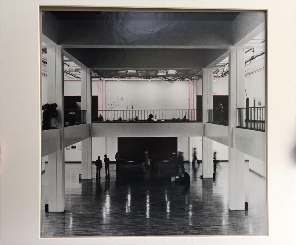 A framed photograph of a two story gallery space has been traced with a red pen, the lines mark a frame around each wall of the exhibition hall.