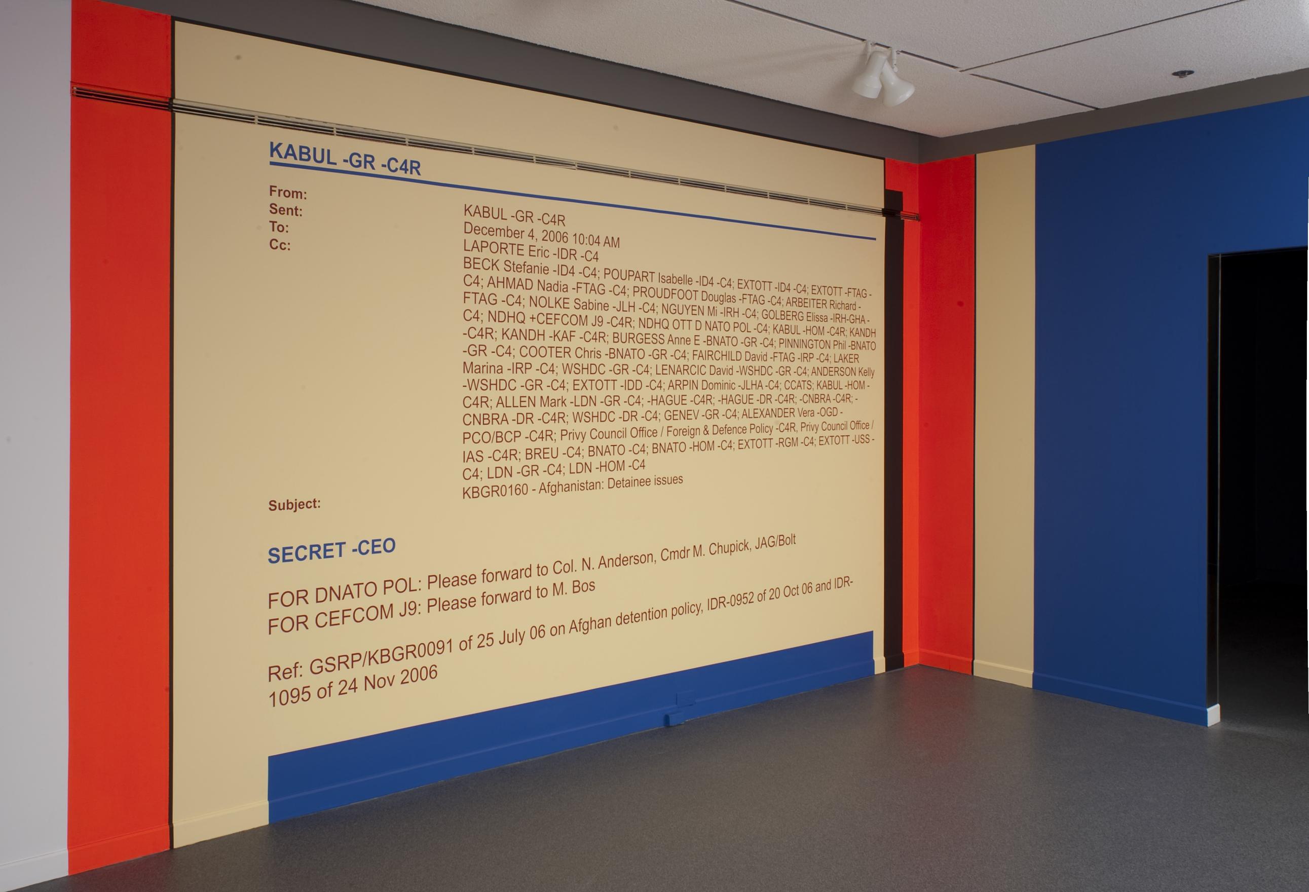 An email is painted on a gallery wall. Red and blue colour blocks frame the legible but confusing words: From: KABUL-GR-C4R. Sent: December 4, 2006, 10:04AM. To: LAPORTE Eric-IDR-C4. A long list of CC’d names, then: KBGR0160 - Afghanistan: Detainee issues. SECRET -CEO FOR DNATO POL: Please forward to Col. N. Anderson, Cmdr M. Chupick, JAG/Bolt. FOR CEFCOM J9: Please forward to M. Bos. Ref: GSRP/KBGR0091 of 25 July 06 on Afghan detention policy, IDR-0952 of 20 Oct 06 and IDR-1095 of 24 Nov 2006.